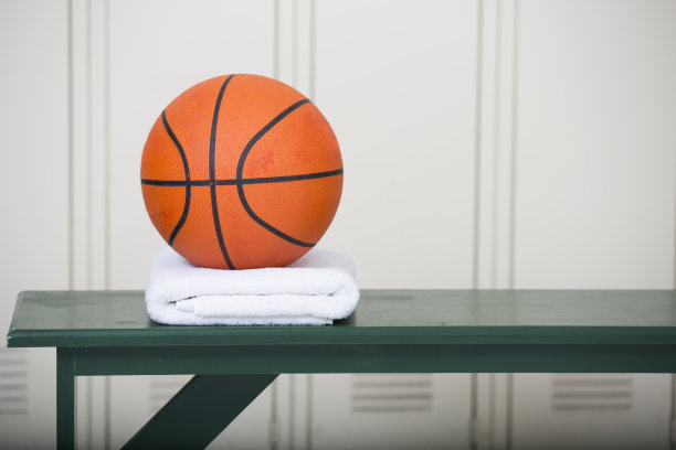 篮球放在更衣室长椅上的毛巾上。图片下载