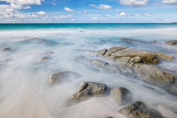 干净的海浪流过海滩上的岩石素材图片