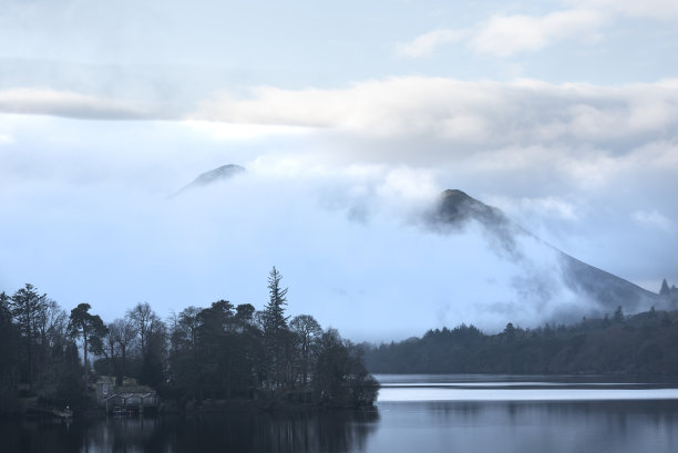 这是一幅引人注目的景观图片，从Derwentwater湖区望向Catbells雪山，浓雾在山谷中翻滚图片下载
