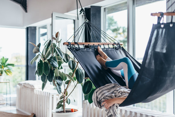 女人正躺在家里的吊床上休息图片下载