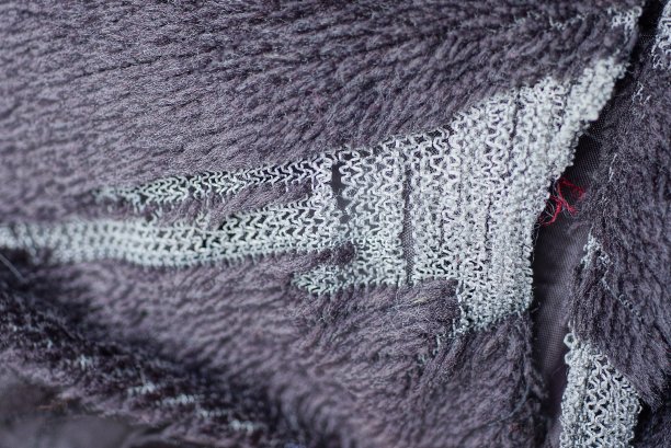 在棕色羊毛物质上撕破白色洞的纹理图片下载