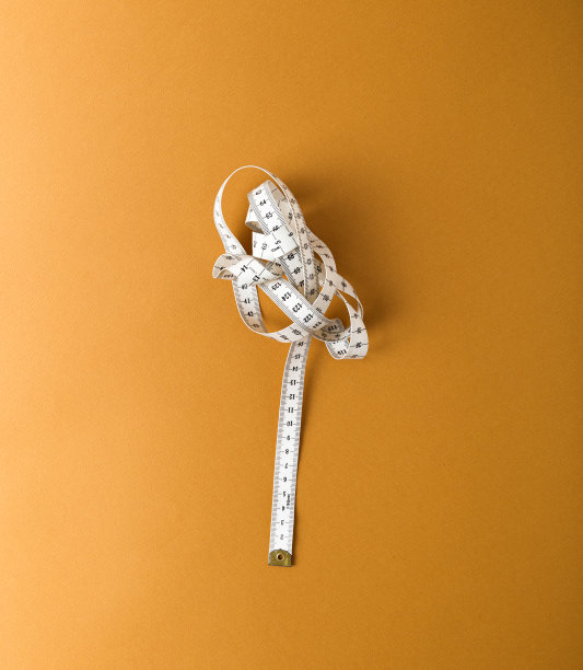 在棕色背景上测量卷尺。俯视图图片下载