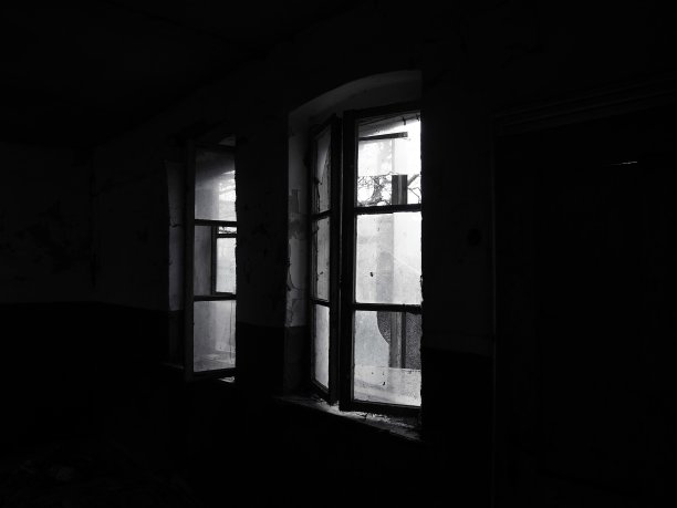 可怕的窗户。在一个废弃的房子里。没有窗帘的破窗户。乏味的东西。光线透过破旧的木框架和破碎的玻璃照射进来。放弃和无用的概念图片下载