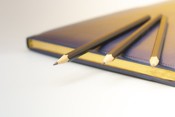 深蓝色的皮革笔记本和三支铅笔。为商务会议做准备。经营理念图片下载