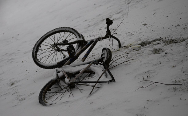 一辆生锈的旧自行车躺在雪地里图片下载