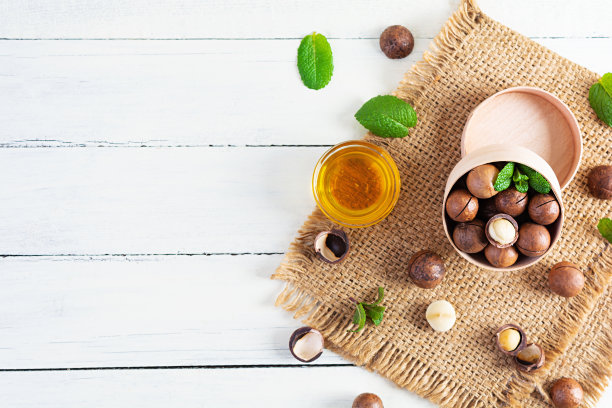 澳洲坚果壳与薄荷叶和蜂蜜在木制背景图片下载