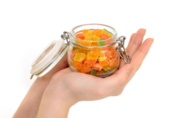 手里拿着糖果。用玻璃制成的装有彩色水果蜜饯、糖豆糖果。孤立在白色图片下载