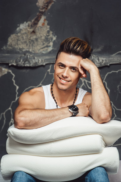 灰色背景下，白色枕头的男人。舒适睡眠的概念。骨科枕头图片下载