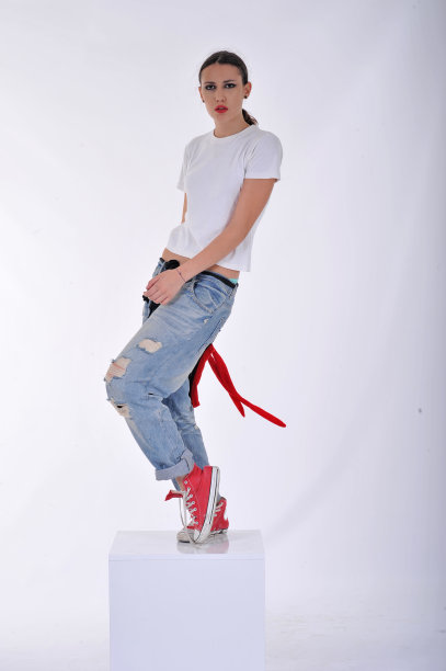 年轻女孩穿蓝色牛仔裤和白色衬衫图片下载