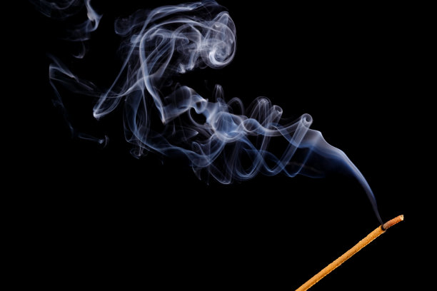 燃烧的香和烟孤立在一个黑色的背景。图片下载