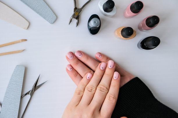 广告背景指甲，美容院，家庭工作用指甲。指甲护理，自我护理。女修指甲。一个人在家修指甲图片下载