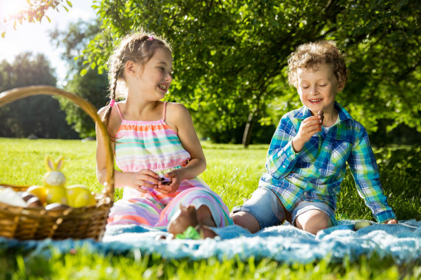 可爱的男孩和女孩庆祝复活节，寻找和吃巧克力蛋图片下载