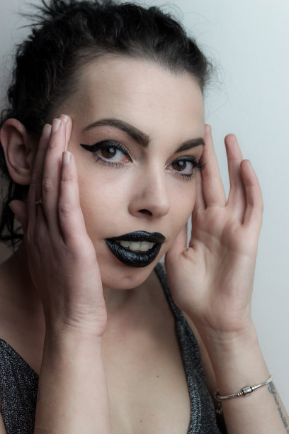 一个年轻女子的肖像，双手放在太阳穴，以说明专注或头痛图片下载