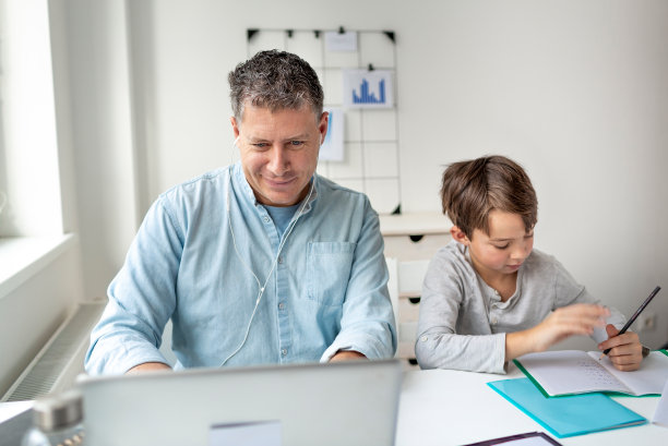 商人在家做家庭办公室和他的儿子在家学习期间科罗纳危机图片下载