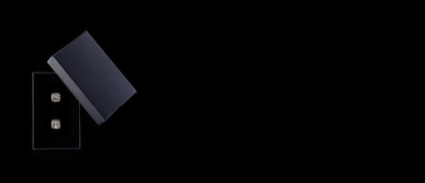 深灰色盒子黑色背景的金耳环。情人节礼物图片下载