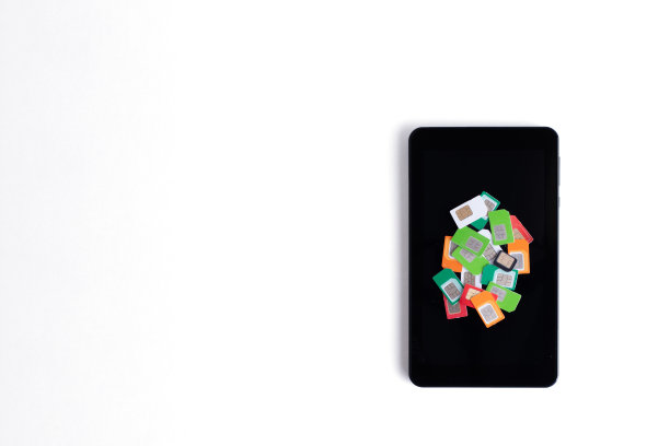 一堆各式各样的sim卡用于蜂窝通信在一个白色背景的手机上，复制空间。移动通信的概念图片下载