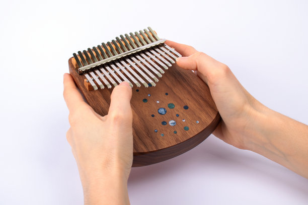 女子为卡林巴演奏近距离。卡林巴或安比拉是一种非洲乐器在白色的背景。音乐的概念。图片下载