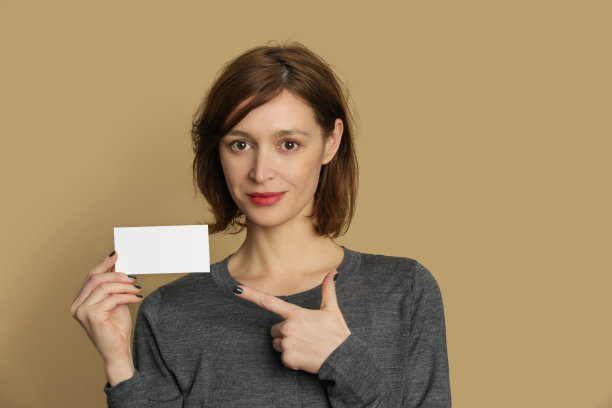 年轻女子的肖像持有空白白纸标签。图片下载