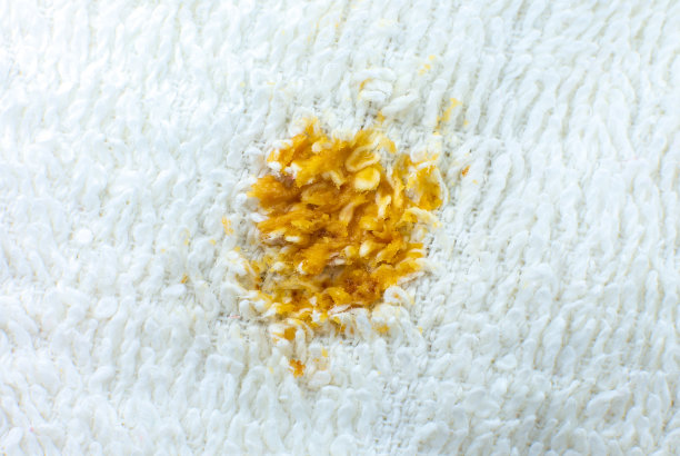 白色棉布毛巾或地毯上有脏的食物污渍。近距离的照片。图片下载