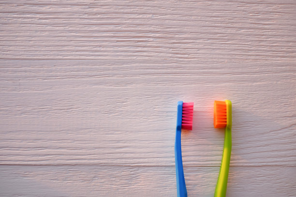 木制背景上的两把塑料牙刷。本空间图片下载