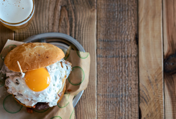 新鲜美味的自制大汉堡放在餐厅简陋的木桌上。图片下载