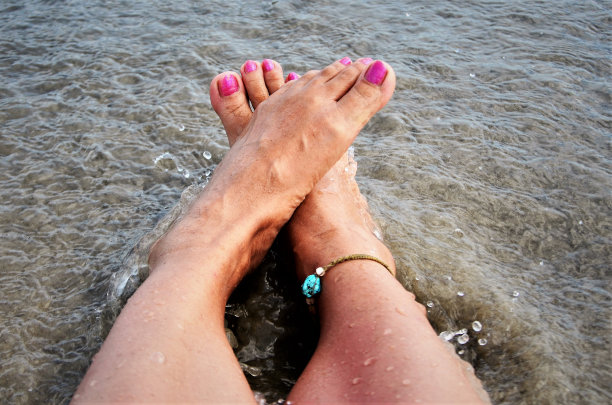 脚在沙滩上的水里图片下载