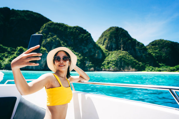 旅游网红成年女性在玛雅湾穿比基尼用手机上网图片下载