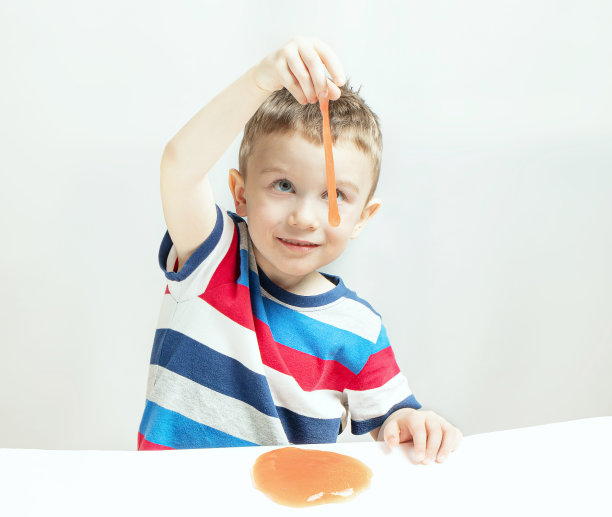 孩子们在玩叫做粘液的手工玩具。孩子们的手玩着黏糊糊的玩具。使粘液。有选择性的重点图片下载