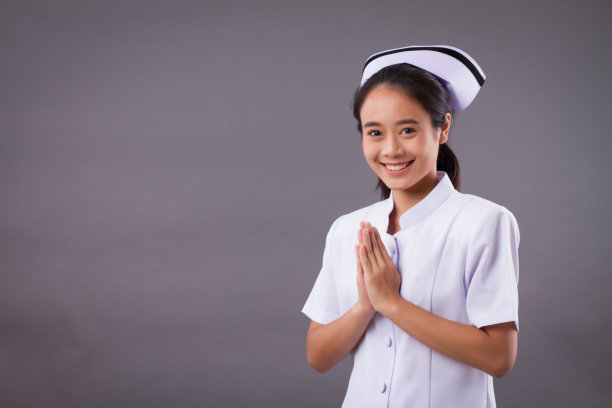 友好微笑的护士与亚洲泰式欢迎手势图片下载