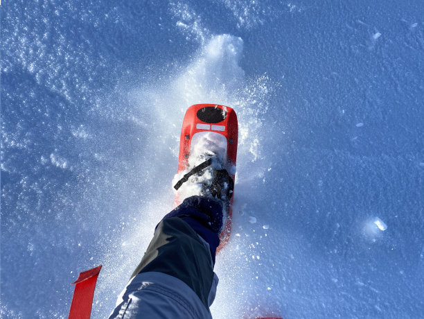 穿着雪鞋在新雪上行走图片下载