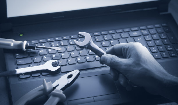 男性的手在电脑键盘上显示扳手。它的服务。支持图片下载