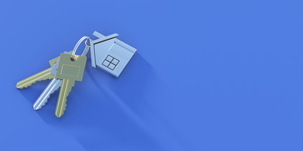 钥匙串在房子形状的钥匙链上，在蓝色背景上。副本的空间。图片下载