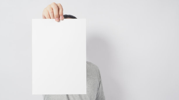 男模特的手拿着空白A4纸，穿着灰色t恤，背景是白色。图片下载