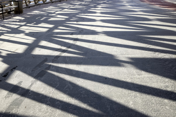 一个金属框架在人行天桥的结冰通道上的几何阴影图片下载