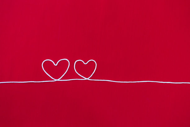 情人节贺卡的背景创意，白色棉线心与空间上的红色织物背景图片下载