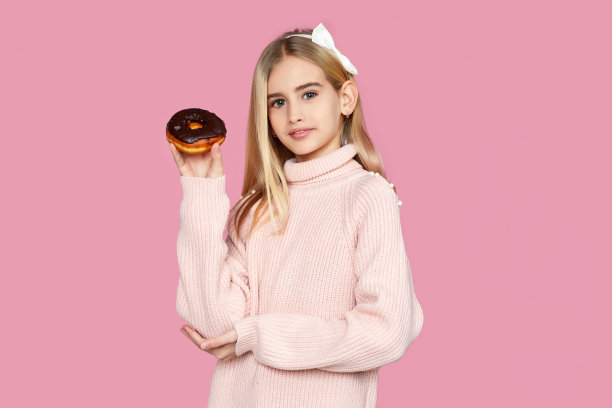 小女孩拿着美味的巧克力甜甜圈图片下载