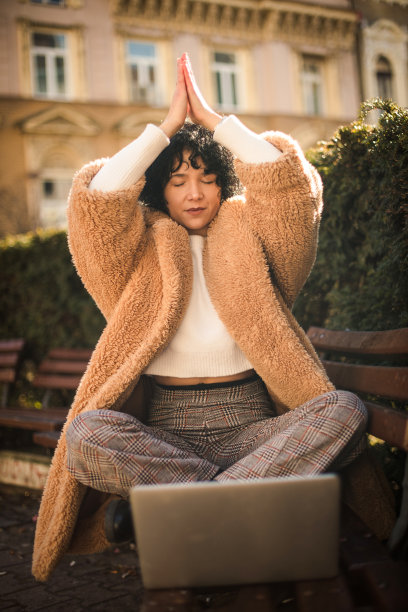 女商人在公园练瑜伽。图片下载