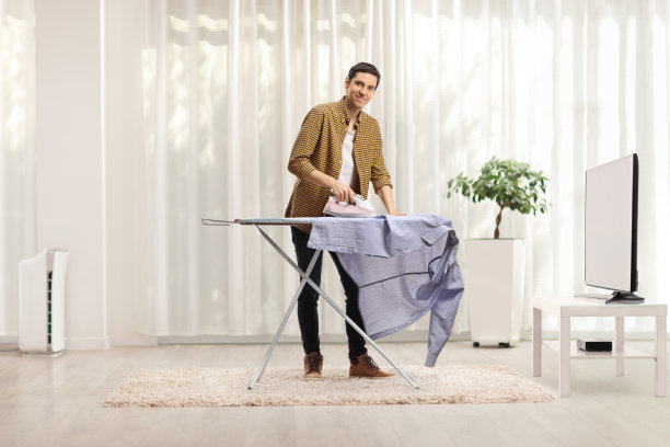 年轻人在家里熨衬衫图片下载