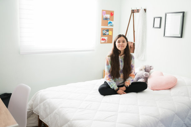 快乐的青少年女孩在周末的卧室里休息图片下载