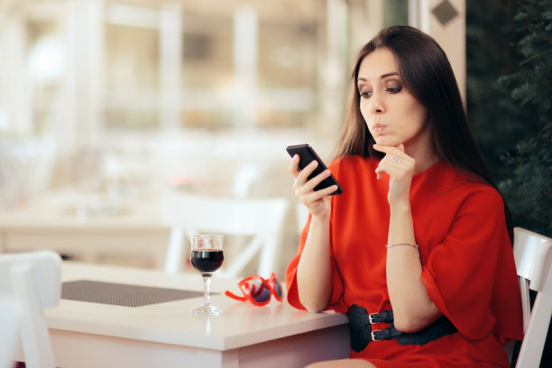 在餐厅等手机的无聊女孩图片下载