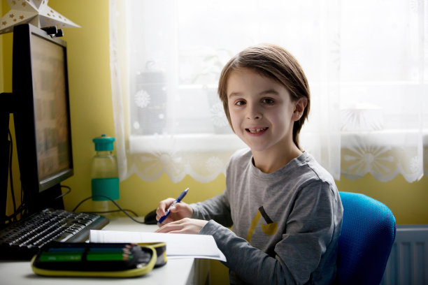 学校的孩子，坐在桌子上用笔记本电脑，写学校任务，而在家上学，流行的远程教学图片下载