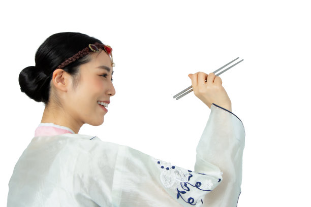 年轻美丽的女人拿着亚洲筷子与大微笑。漂亮的年轻女人，有完美的微笑牙齿。孤立在白色的。亚洲女孩穿着传统韩服风格的肖像图片下载