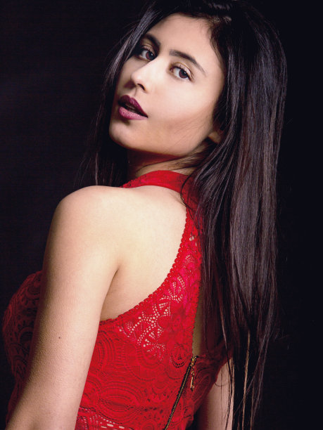 穿着红色蕾丝连衣裙的女人。在摄影棚拍摄人像。黑色背景图片下载