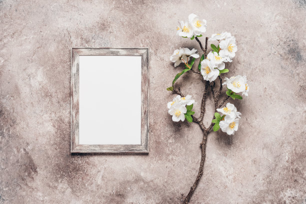 空人像框模型和装饰樱花枝人工在米色垃圾背景。俯视图，平放。您的设计的Spring模板。图片下载