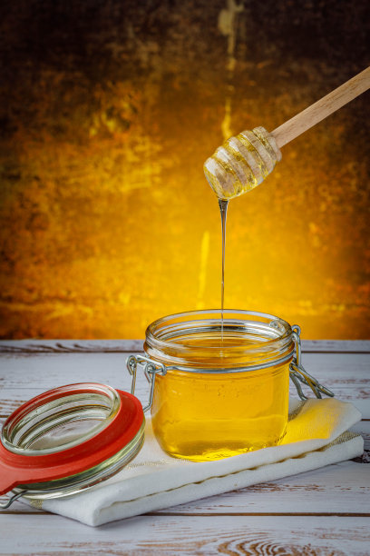 木色背景的罐子里的蜂蜜图片下载