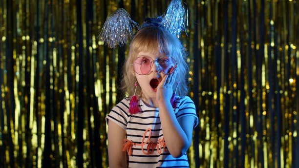 时髦的女孩用大大的眼睛惊讶地看着镜头举起手来，被胜利惊呆了，说哇图片下载