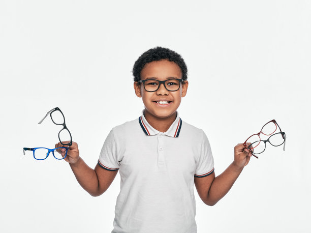 非裔美国男孩手中拿着许多时髦的眼镜，为儿童矫正视力，在白色的背景图片下载