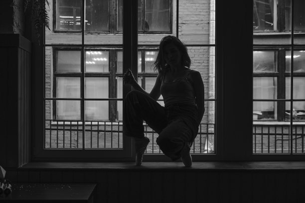 黑白照片的舞者在一个老建筑的窗框。年轻、优雅、优雅的芭蕾舞女演员图片下载