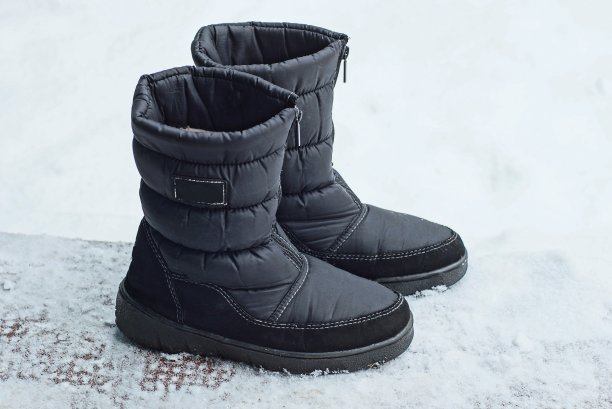 两只巨大的黑色靴子站在洁白的雪地上图片下载