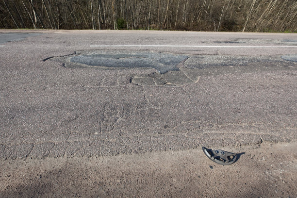 路面坑坑洼洼，质量很差。洞沥青。坑，不安全，坑路。运输图片下载